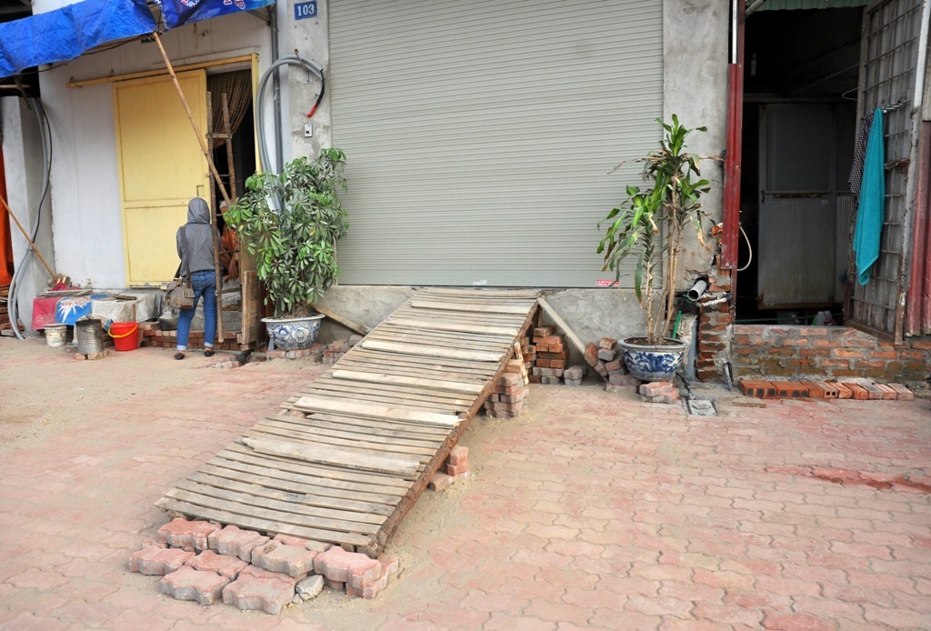 
Trong khi đó, không hiếm những căn nhà cao hơn mặt đường cả mét. Người dân phải bắc cầu thang vào nhà.
