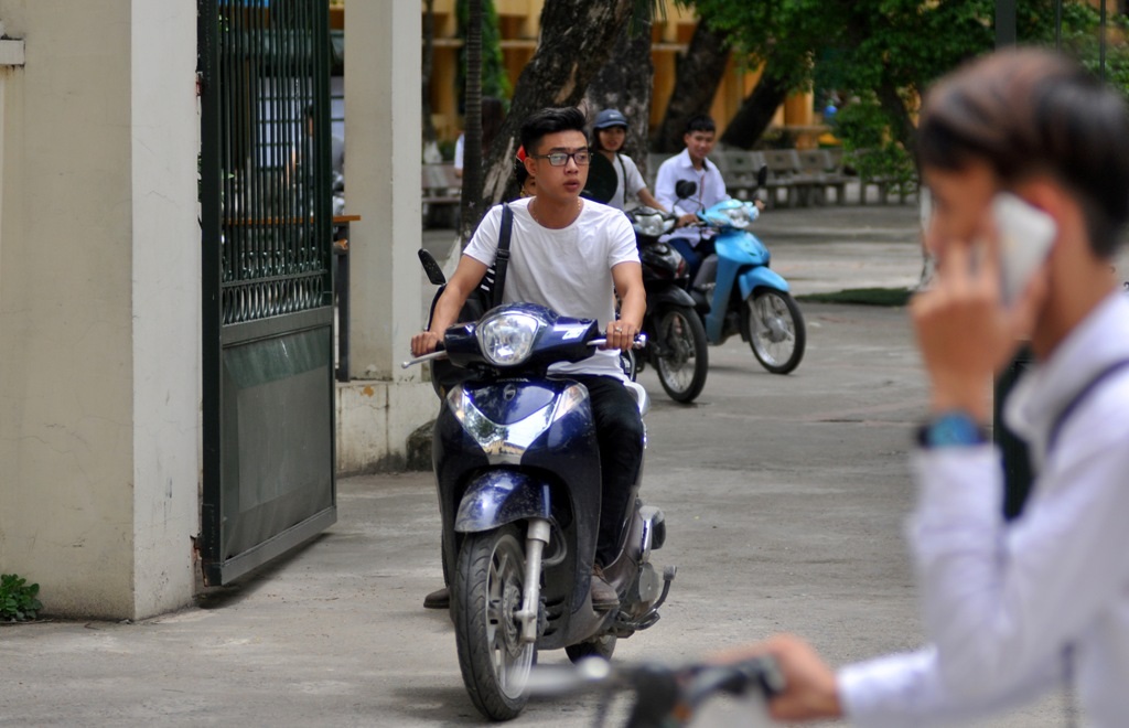 Nhiều em học sinh mang mũ bảo hiểm nhưng lại treo ở xe mà không sử dụng.