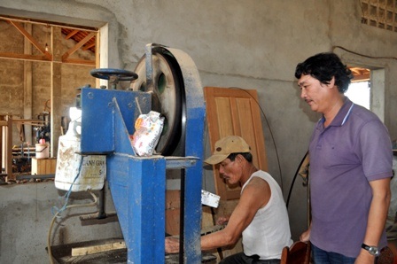 Cựu chiến binh Trần Trung Xê đang chỉ bảo công việc cho công nhân