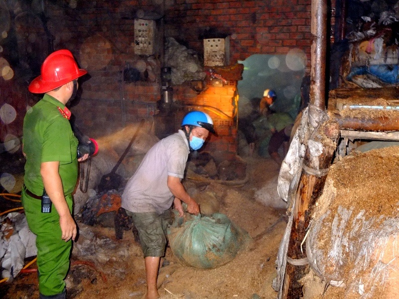 
Các công nhân di chuyển thiết bị trong nhà xưởng ra ngoài khi ngọn lửa bắt đầu bùng phát
