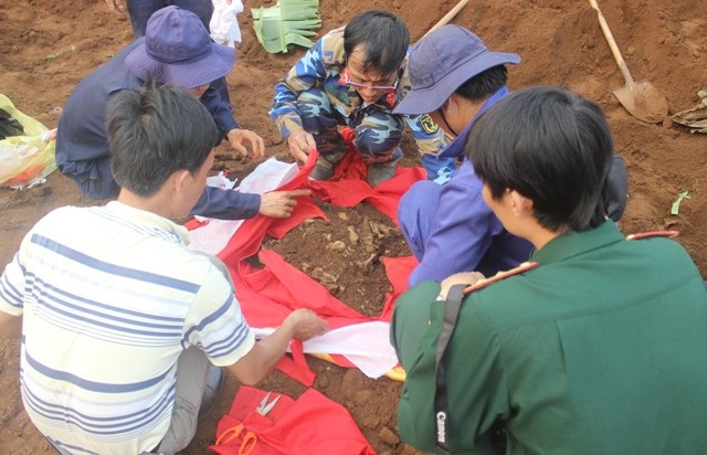 Thượng tá Trần Quang Lục, Chính trị viên Bộ Chỉ huy Quân sự tỉnh (đeo kính) cùng các đồng đội cất bốc hài cốt liệt sĩ