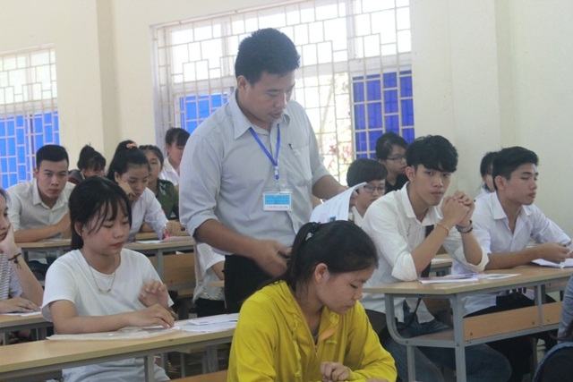 
Cán bộ coi thi phát thẻ dự thi và phổ biến quy chế thi. (Ảnh Đăng Đức)
