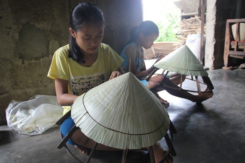 
Tranh thủ nghỉ hè, Hoài và em gái phụ giúp đan nón lá để kiếm thêm thu nhập
