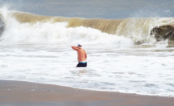 Cơn sóng mùa biển động cao vút, cuộn tròn nguy hiểm nhưng có lẽ du khách này đang thách thức nó