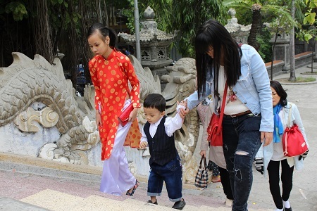 Một em bé theo mẹ lên chùa lễ phật