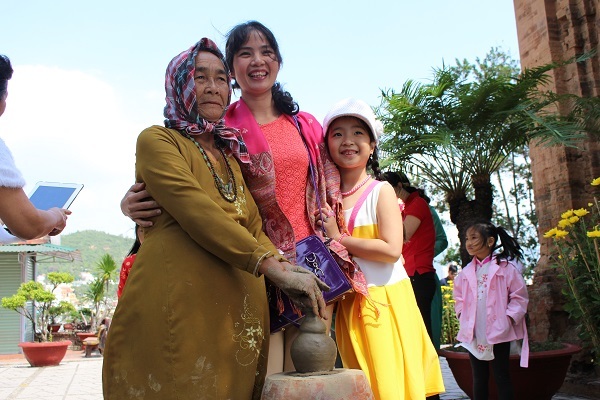 Du khách háo hức chụp hình với nghệ nhân Chăm đầu năm mới