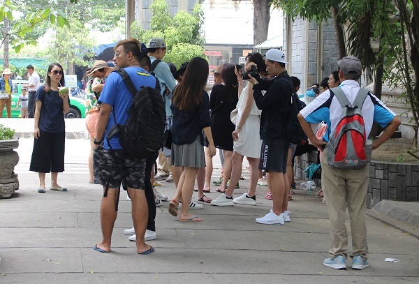 Hướng dẫn viên người Trung Quốc (áo xanh, dép lê) sau khị ống kính chụp vì thuyết minh trái phép ở chùa Long Sơn (TP Nha Trang) đã lẳng lặng bỏ đi - Ảnh: Viết Hảo