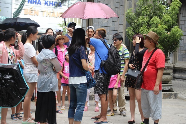 Một HDV người Trung Quốc thuyết minh trái phép ở chùa Long Sơn, TP Nha Trang - Ảnh: Viết Hảo