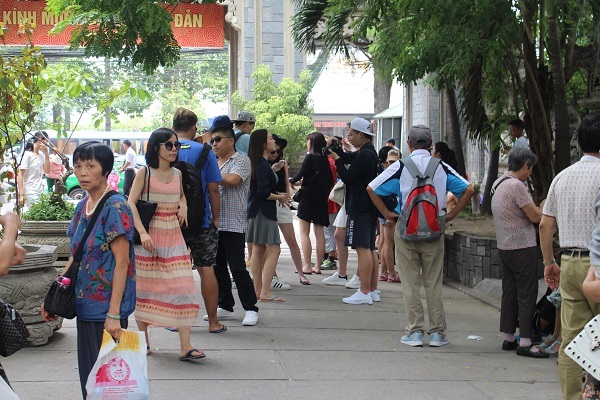 Một HDV Trung Quốc (áo xanh, đeo ba lô) giả vờ lơ sau khi bị ống kính chụp về hành vi thuyết minh trái phép ở chùa Long Sơn, TP Nha Trang - Ảnh: Viết Hảo