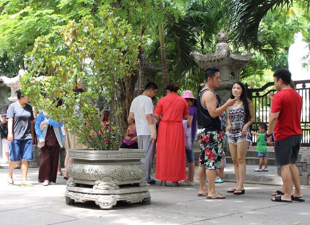 Du khách Trung Quốc nghỉ chân dưới bóng mát ở chùa Long Sơn (TP Nha Trang)