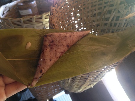 Bánh a quát chín, bóc tách từng lớp lá sẽ hiện ra chiếc bánh có màu đen phớt hồng.