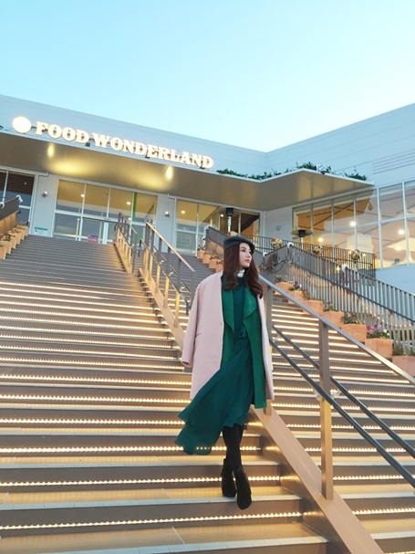 Váy xanh ngọc lục bảo kết hợp cùng áo dạ khoác dạ kiểu cách tối giản.