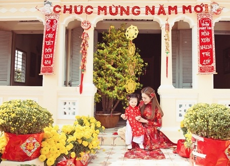 Trong bộ ảnh, bà mẹ hai con lúc ngọt ngào, nổi bật trong trang phục áo dài gấm đỏ họa tiết hoa thêu…