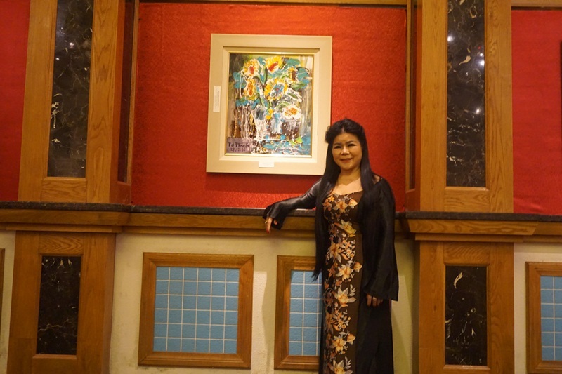 Nữ họa sĩ Văn Dương Thành bên một tác phẩm nghệ thuật của mình.
