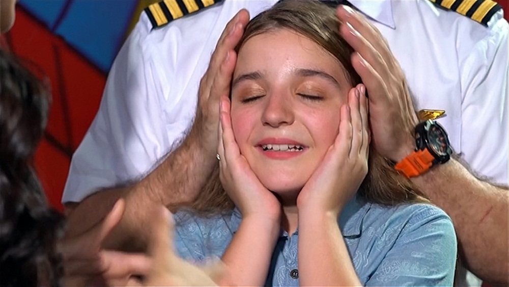 Ấn tượng trước giọng hát và khả năng cảm thụ âm nhạc của Milana, cô giáo dạy nhạc cho em đã động viên cô bé thử sức ở Giọng hát Việt nhí. Trong ảnh là Milana hạnh phúc trong vòng tay bố khi được xướng tên đi tiếp.