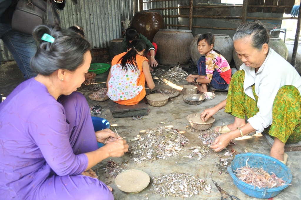 Vào lò sản xuất khô “vũ nữ chân dài” lớn nhất miền Tây - 4 Mỗi người lao động làm nhái đều có một cái tô (bát) đựng cát kế bên để lột nhái không bị trơn. Trung bình 1kg nhái lột xong mỗi lao động được trả công từ 25.000 - 35.000 đồng