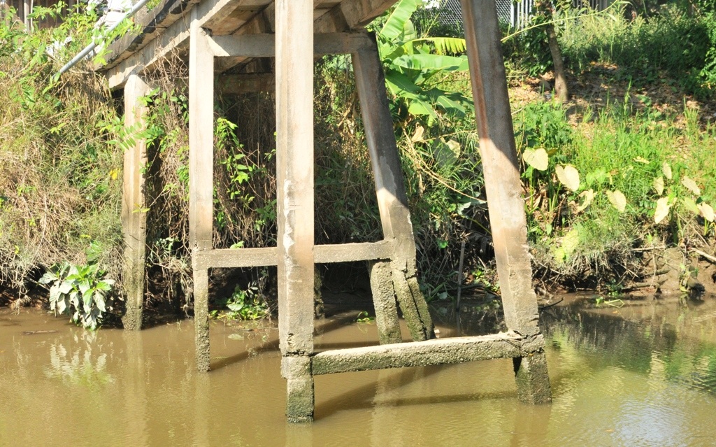 Học sinh run rẩy qua cầu bê tông già cỗi đến trường - 4
Một số trụ cầu bị gãy được gia cố thêm, số còn lại bị nước bào mòn nay chỉ to bằng cẳng chân người
