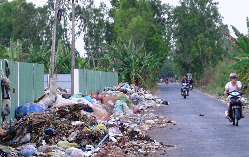 Ăn cùng ruồi, ngủ cùng... mùi hôi thối! - 1 Những năm trước bãi rác xã Phú Hựu tràn ra cả đường đi.