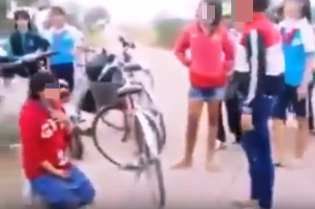 Clip ép nữ sinh ăn cát: Trên cả sự vô cảm - 1 Tất cả những nhân vật trong vở diễn bắt nữ sinh ăn cát và khán giả đều không thể hiện cảm xúc gì (Ảnh cắt từ clip)