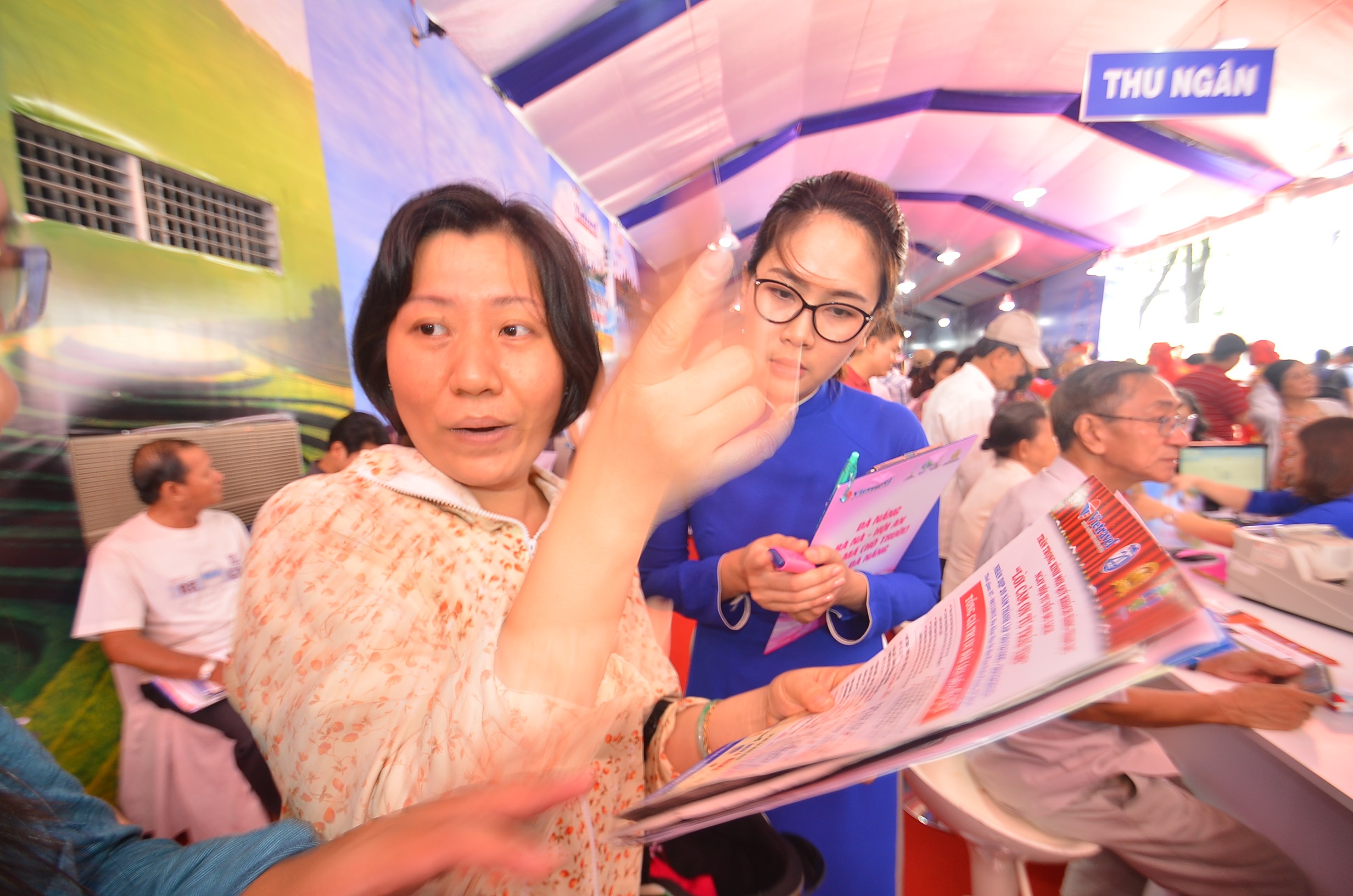 Do lượng khách tham quan quá đông nên nhân viên phải chủ động tư vấn du khách bằng tờ rơi.