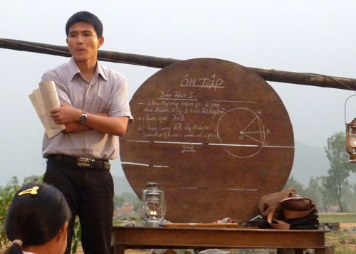 Những người thầy gây xúc động mạnh trên màn ảnh Việt - 6 Cảnh thầy giáo Nguyên mang bảng gỗ đi dạy học cho học trò trên bãi cát trong Rừng chắn cát.