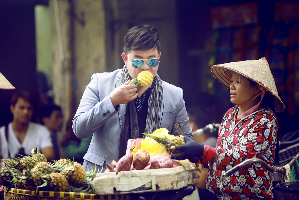 Quang Lê đứng ăn quà vặt, rít thuốc lào giữa phố Hà Nội - 8 Mua dứa rồi đứng ngay giữa đường ăn một cách ngon lành. Sự tự nhiên của nam ca sỹ đã khiến cho khoảng cách của anh với những người yêu nhạc của anh gần hơn.