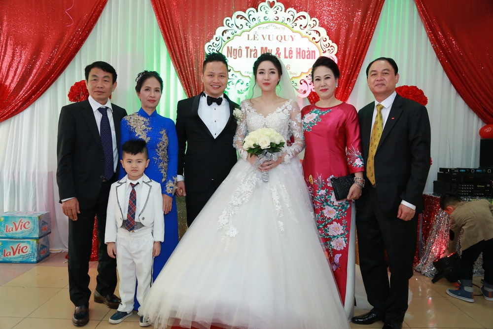 
Cô dâu và chú rể chụp ảnh với người thân trước khi chính thức bước lên xe hoa về nhà chồng.
