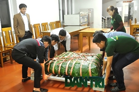 6 thanh niên lực lưỡng bê chiếc bánh ra hệ thống Pa lăng xích để cẩu vào nồi.