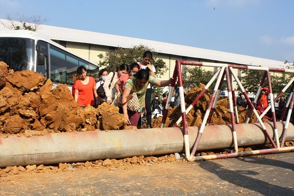 Một số công nhân phải gửi xe bên ngoài, leo qua hàng rào đất đá, bê tông... để vào công ty làm việc