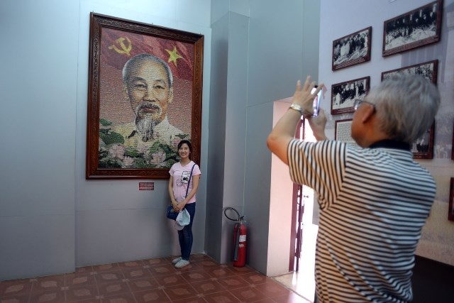Hình ảnh Bác Hồ tại nơi Người ra đi tìm đường cứu nước 105 năm trước - 4 Khách tham quan chụp hình bên ảnh Bác