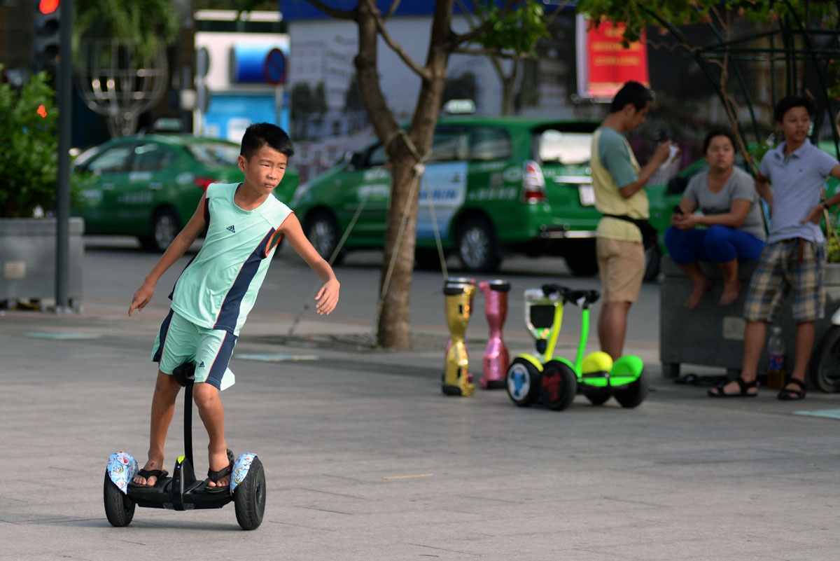 Khách Tây thích thú chơi xe điện trên phố đi bộ Sài Gòn - 12 Một em nhỏ tỏ ra “sành điệu” khi di chuyển trên xe điện thăng bằng.