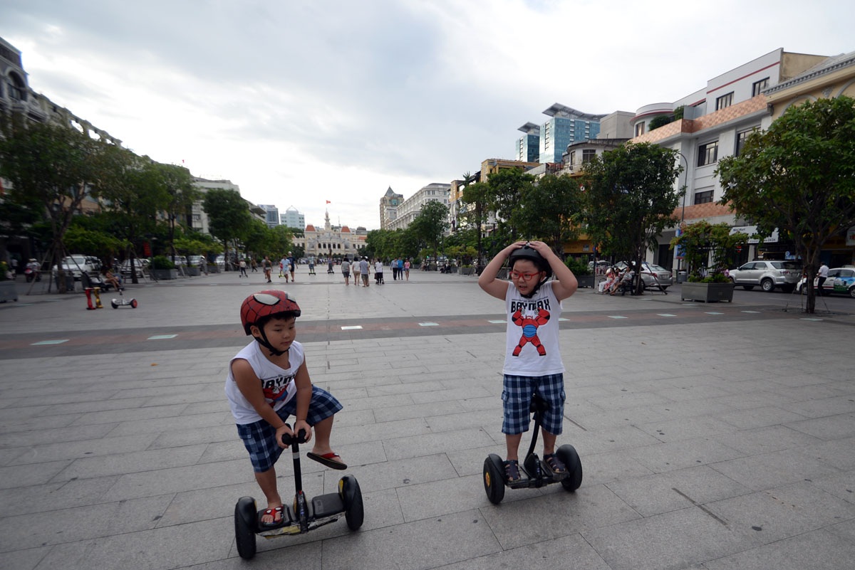 Khách Tây thích thú chơi xe điện trên phố đi bộ Sài Gòn - 9 Hai em nhỏ thường xuyên ra chơi trò chơi, để an toàn các em đội nón bảo hiểm