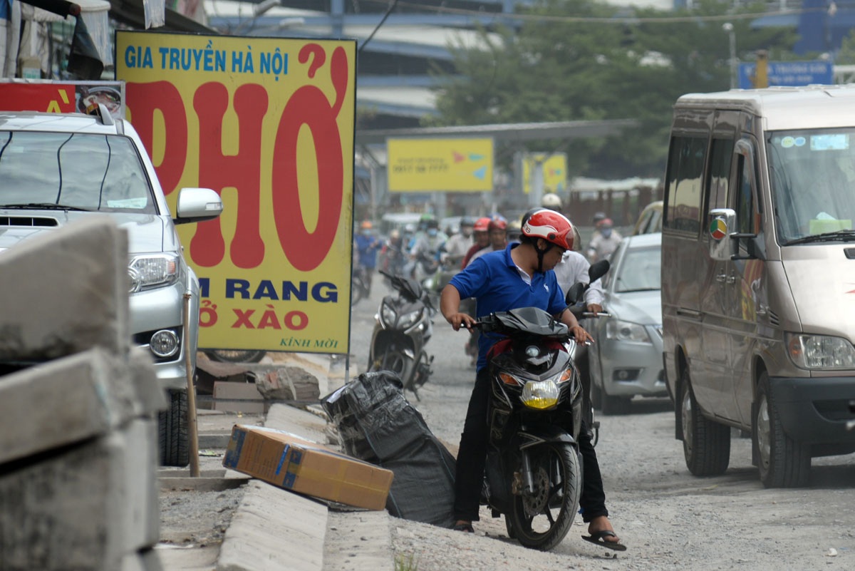Bụi mù mịt giữa trung tâm Sài Gòn - 5 Người đàn ông chở hàng bị đổ xuống đường vì đường quá gập ghềnh