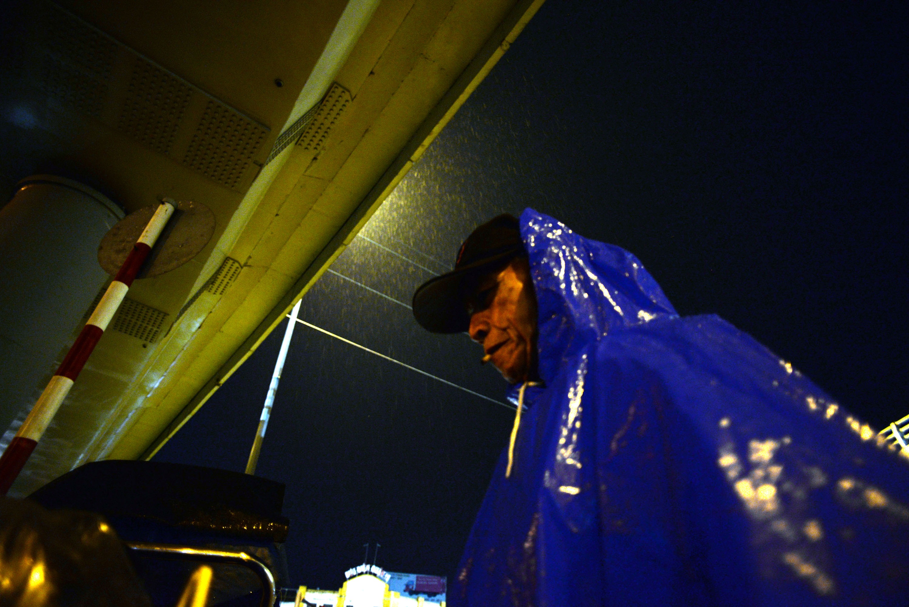 Những phận người nghèo trong đêm mưa Sài Gòn - 4 Ông Sáu đã chạy xích lô hơn 30 năm ở Sài Gòn. Ông đã quá quen với những cơn mưa chợt đến rồi chợt đi. Tầm 23 giờ đêm, ông Sáu vẫn cố mang áo mưa chạy chở hàng cho khách quen xong mới về lại chân cầu nghỉ ngơi.