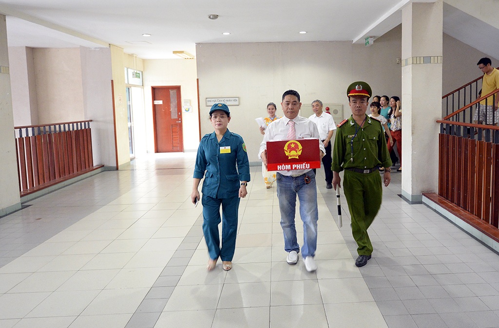 
Hòm phiếu được bê trang trọng tới tận giường bệnh và được bảo vệ nghiêm ngặt bởi lực lượng công an và dân phòng.
