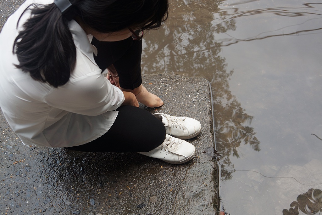 
Người đến bệnh viên không tìm được đường đi, đành phải tháo giầy lội qua nước bẩn.
