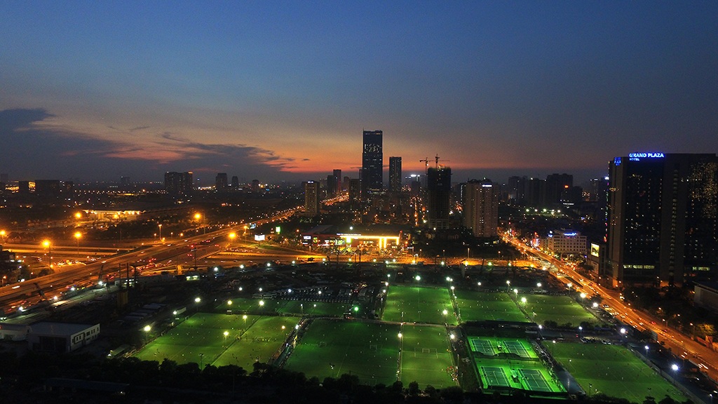 
Sân bóng đá mini sáng điện trong đêm, giữa những khu đô thị hiện đại của thành phố.
