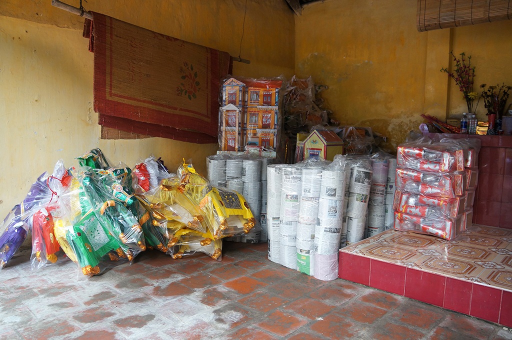 
Tháng 7 Âm lịch, hàng hóa tập kết đầy đường làng, sân nhà hộ dân. Trong ảnh, một góc nhà thờ họ cũng được tận dụng làm nơi để vàng mã.
