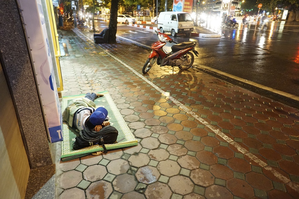 Dễ dàng bắt gặp những người đang ngủ ngon lành trên hè phố trong đêm mưa lạnh đầu mùa ở Hà Nội.