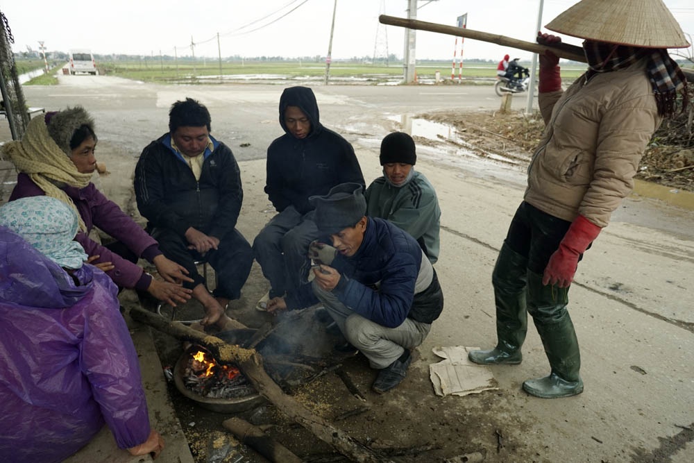 Nông dân Hà Nội lội ruộng trong cái rét cắt da cắt thịt - 6 Nhiệt độ xuống thấp kỉ lục, những người nông dân thôn Song Khê làm việc ngoài đồng phải đốt lửa sửa ấm.