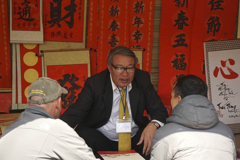 Xin chữ đầu năm, "ông đồ" vắng, "ông đồ "đông" - 4 Nhiều ông đồ theo phong cách thoáng hơn với bộ áo vét và đeo cà-vạt.