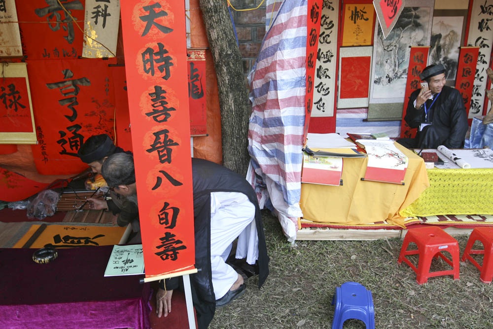 Xin chữ đầu năm, "ông đồ" vắng, "ông đồ "đông" - 5 Các ông đồ đang viết chữ, mỗi người một phong cách và tỏ ra rất thoải mái. Lượng người đi xin chữ trong buổi sáng mùng 2 Tết vẫn khá vắng, trong khi tại Văn Miếu thì rất đông đúc.