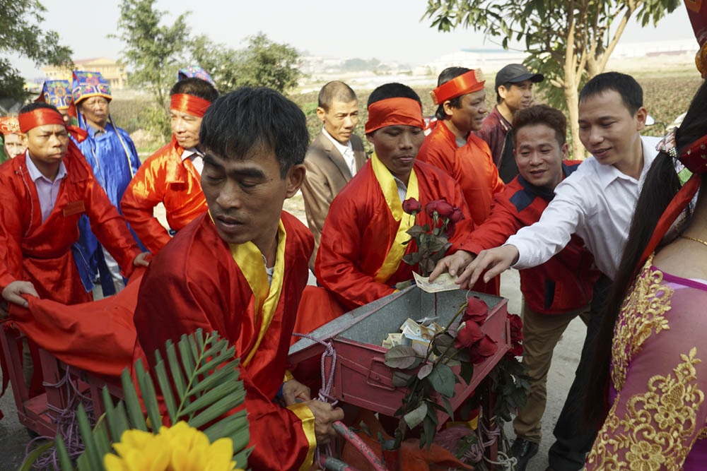 Hội làng Ném Thượng: Không còn cảnh chém lợn giữa sân đình - 6
Khi đoàn rước đi qua, người dân đứng chờ sẵn để bỏ tiền vào xe rước ông ỉn hoặc đưa bánh kẹo, nước uống cho những người đẩy xe.