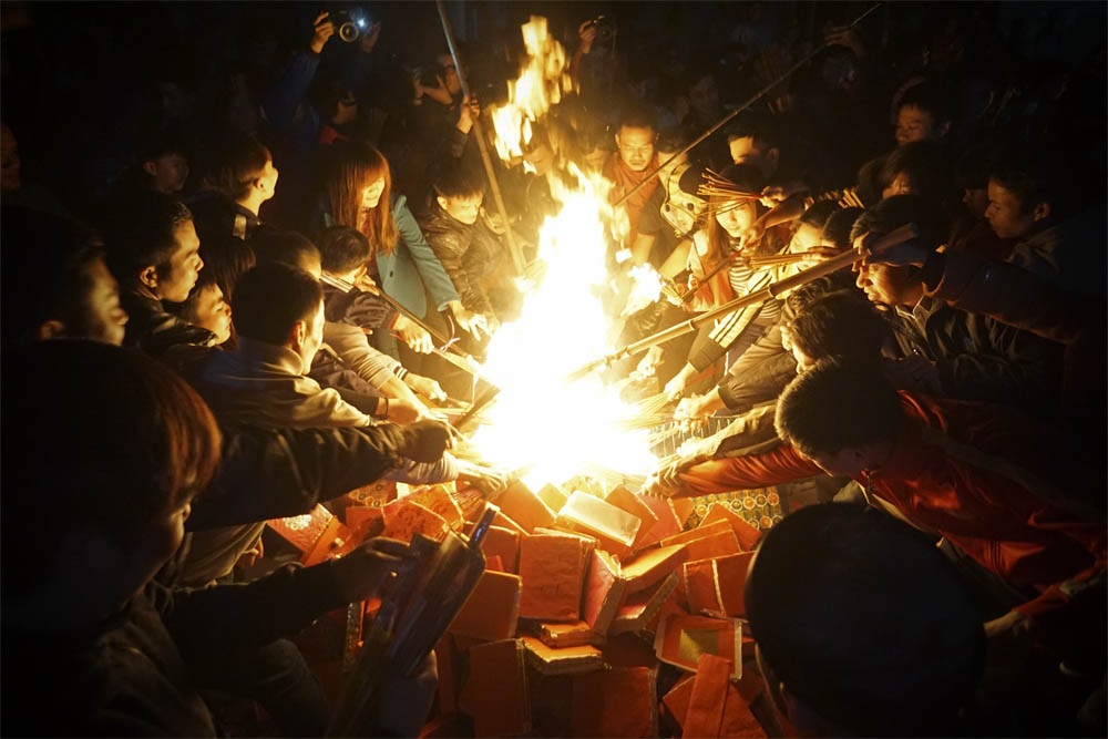 Chạy thục mạng "lấy đỏ" cầu may - 9 Vàng mã được hóa, dân làng đổ xô vào ngọn lửa với trên tay những bó hương ngắn dài đủ loại châm lửa thật nhanh.