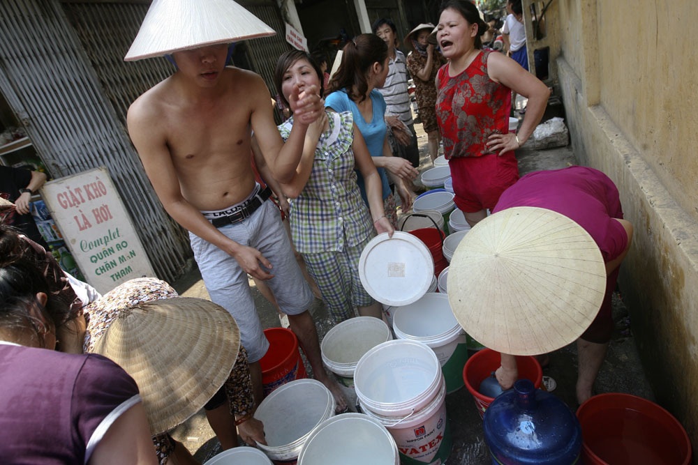 Vui - buồn cùng nước - 5 Người dân phường Thịnh Liệt, quận Hoàng Mai - TP Hà Nội đang xếp hàng chờ xe chở nước sạch để lấy nước sinh hoạt. Vào mùa hè năm 2014, nơi đây bị mất nước hàng tháng trời đúng thời điểm nắng nóng gay gắt.
