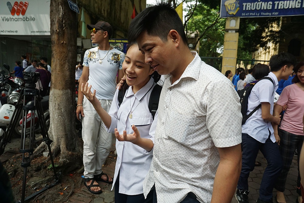 Cảm xúc vỡ òa của thí sinh, phụ huynh sau buổi thi đầu tiên vào lớp 10 - 6
Một thí sinh đang thuật lại bài làm của mình cho bố bên ngoài cổng trường.