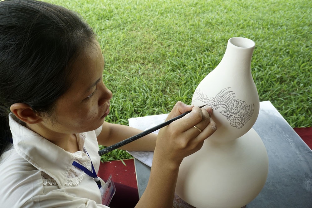 
Trình diễn vẽ gốm của thợ thủ công làng nghề gốm cổ Bồ Bát, đơn vị cho biết làng nghề có truyền thống 3000 năm tại xã Yên Thành (huyện Yên Mô, Ninh Bình), khi xưa một số thợ gốm của làng đã di dời về Bát Tràng để lập nghiệp.
