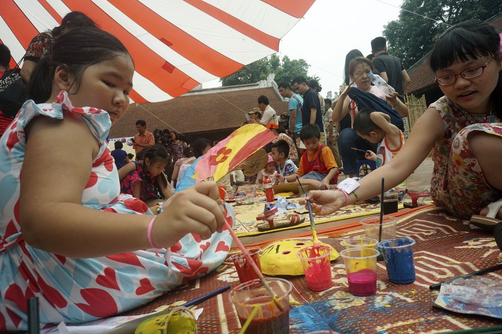 Hàng trăm em nhỏ tập làm mặt nạ giấy bồi chơi Tết Trung thu - 3
Sau đó hong khô và bắt đầu dùng bột màu để vẽ thực hiện ý tưởng.