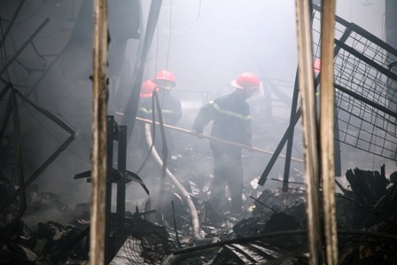 Các chiến sỹ PCCC đang phun nước trong làn khói dày đặc tại hiệu sách Hương Khang