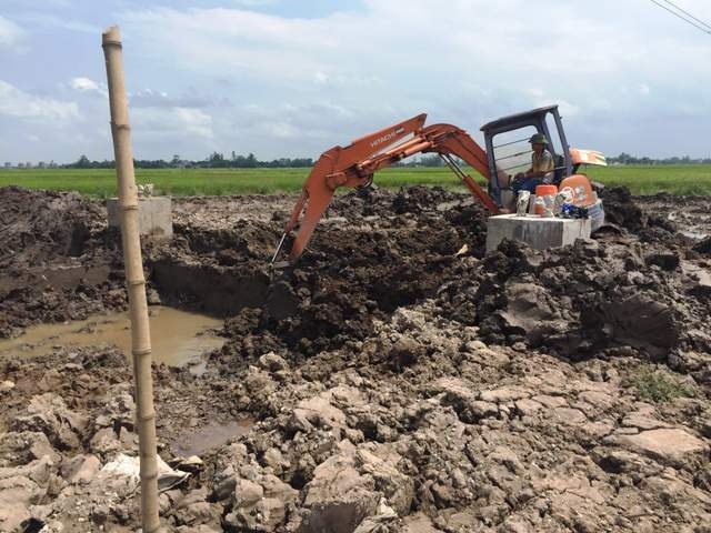 
Máy xúc xúc lớp đất bề mặt trên trụ điện
